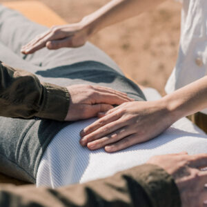 Dos personas aplicando Reiki a una paciente para el bienestar