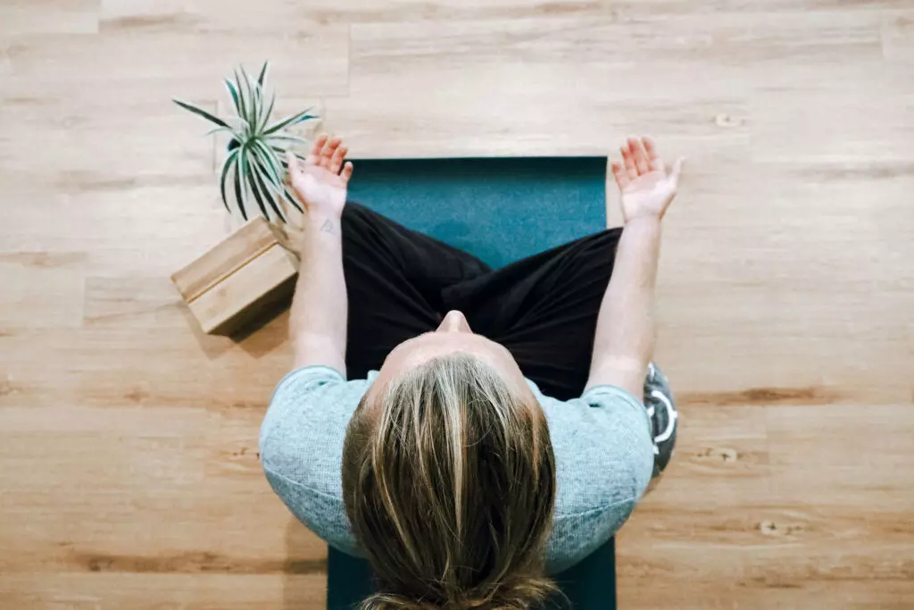 Chica practicando meditación zen en casa.